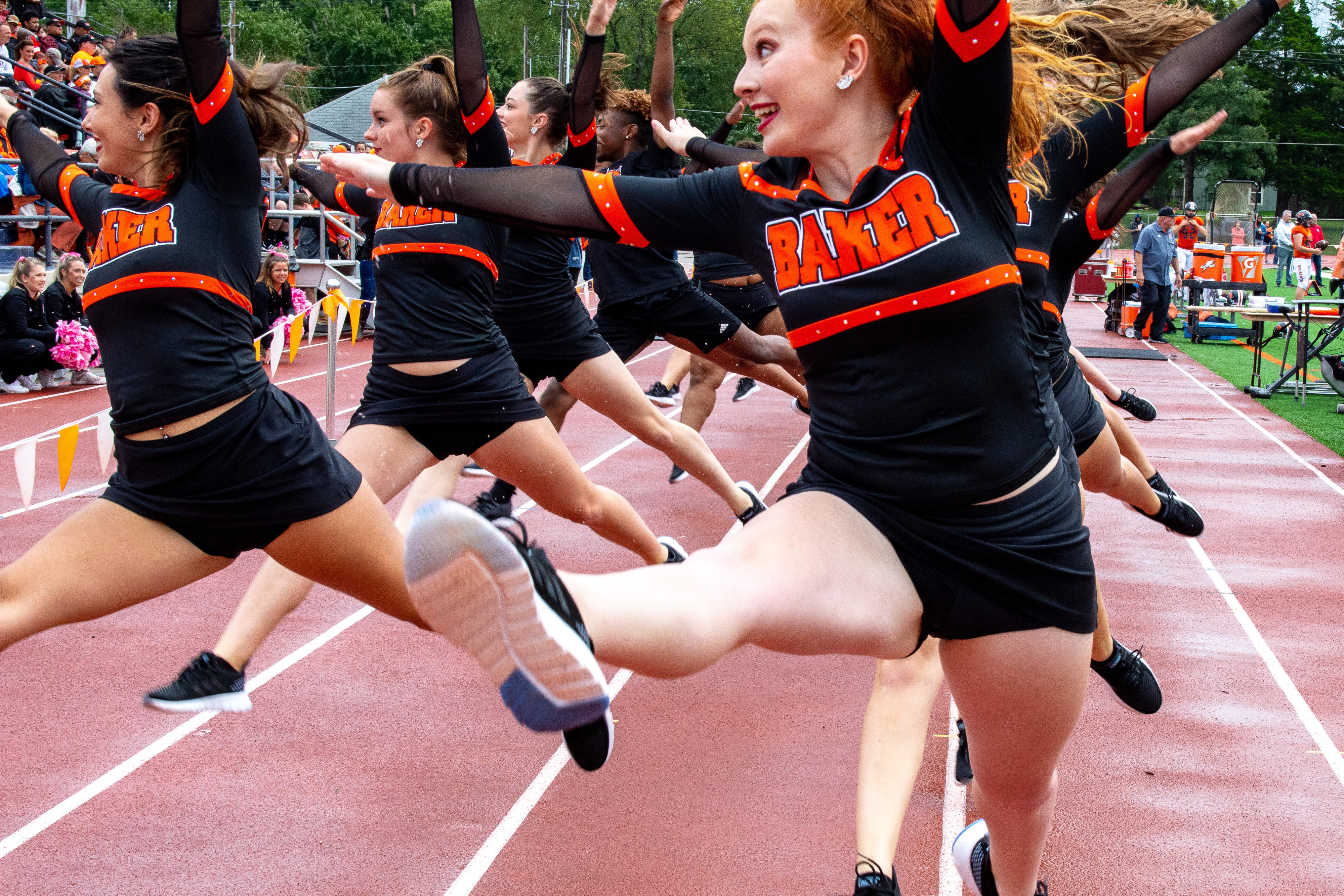 Cheerleaders at Baker College football field performing for homecoming